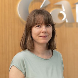 Porträt von Judit Göndöcs, Nachhaltigkeitsbeauftragte von Canon Austria, vor Firmenlogo (c)2025, Saubermacher