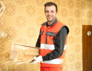 Saubermacher-Mitarbeiter mit Holzabfällen in einem Raum bei privater Entrümpelung, ideal für Muldenservice und Sperrmüllentsorgung – Saubermacher ©2023, Saubermacher, KumpPhotography