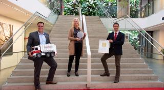 Saubermacher als Arbeitgeber dreifach ausgezeichnet Harald Gorucan, Annemarie Gräßler und Vorstandsvorsitzender Ralf Mittermayr mit dem Staatspreis Familie an der Stiege des Saubermacher Ecoports.